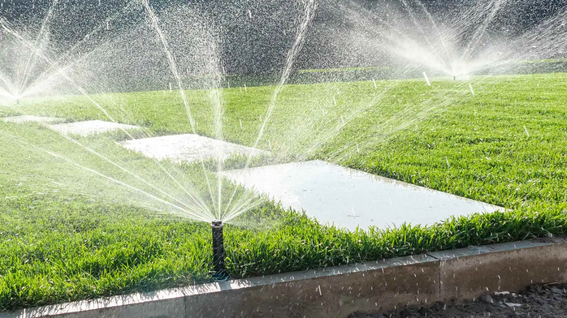 Irrigation systems sprinkling water over lawn in Little Rock, AR.