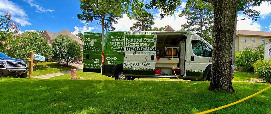 Thick, green grass and Natural State Horticare work van at a home in Little Rock, AR.